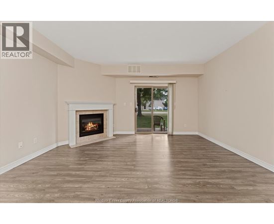 A spacious room with a fireplace and a door leading to a balcony.