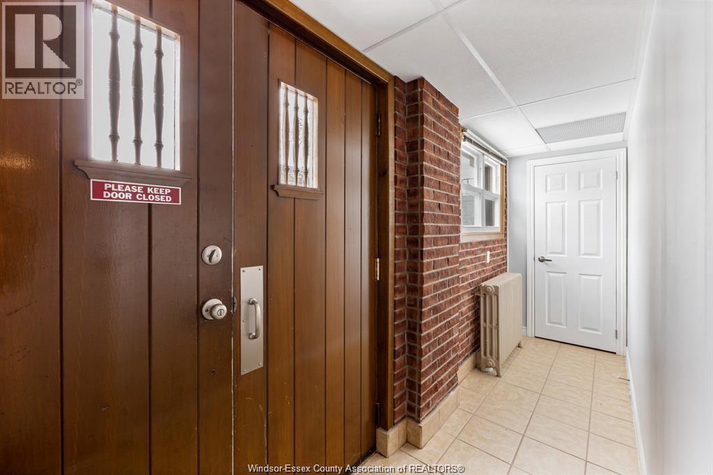 A hallway with a closed door and a sign that says "Please keep door closed".
