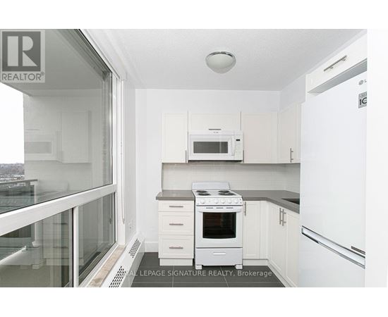 A small white kitchen with a microwave and stove.