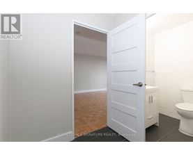 A white door is open to a bathroom with a toilet.