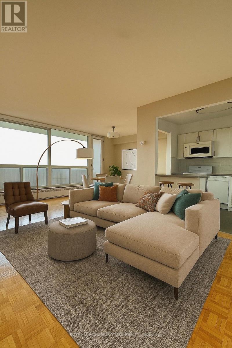 A living room with a couch, chair, ottoman, and a window.