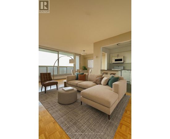 A living room with a couch, chair, ottoman, and a window.