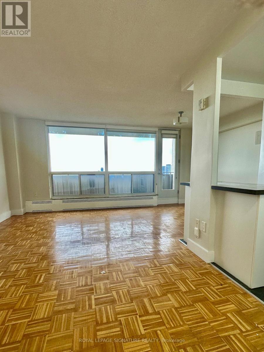 A room with wooden flooring and a large window.
