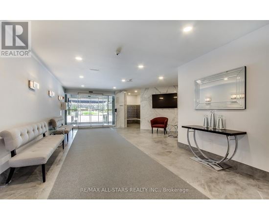 A spacious office lobby with a reception desk and a row of comfortable chairs.