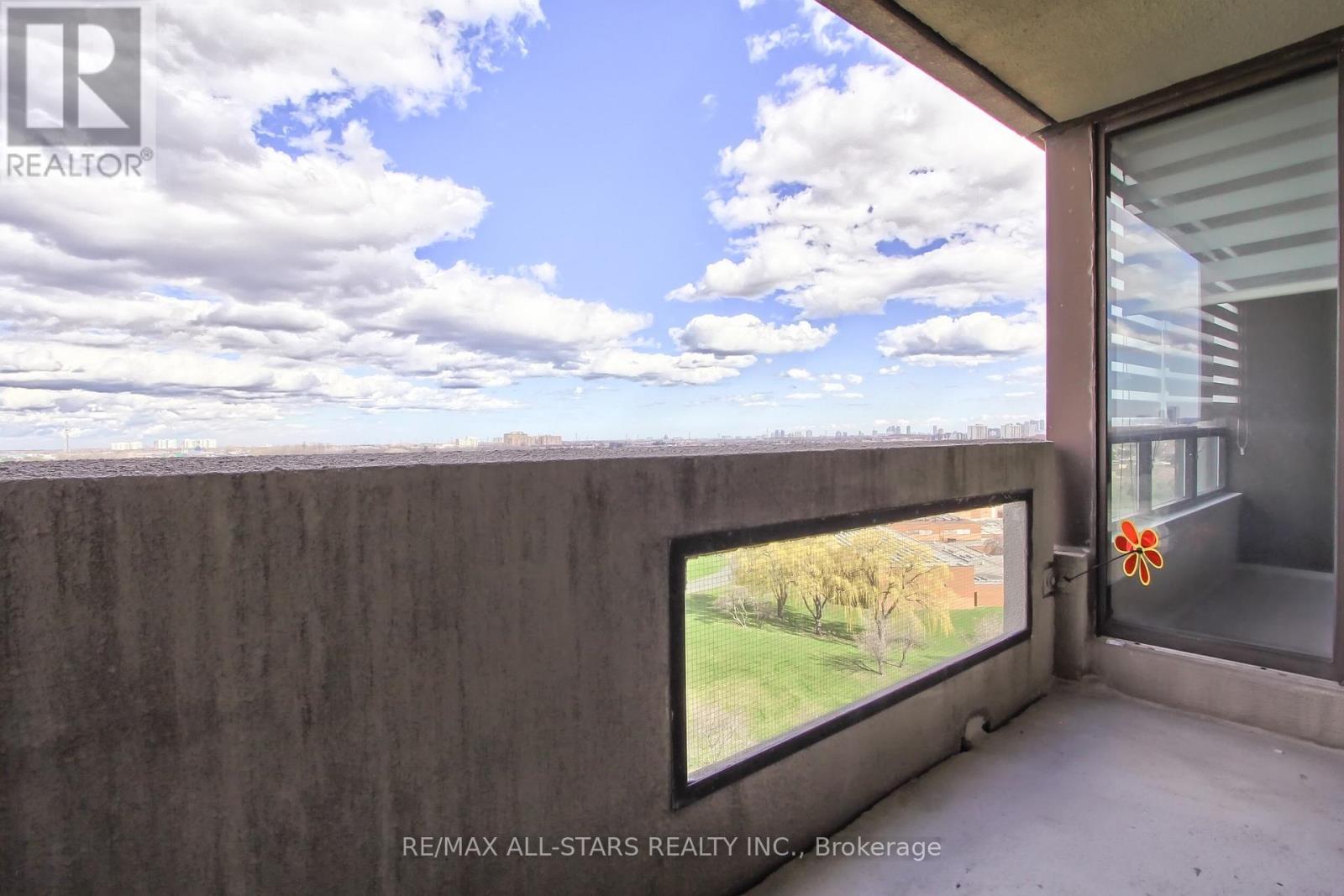 A balcony with a view of the sky and trees.
