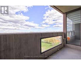 A balcony with a view of the sky and trees.