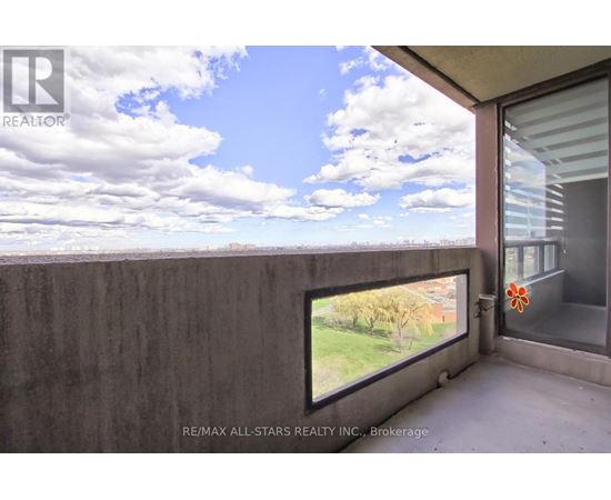A balcony with a view of the sky and trees.