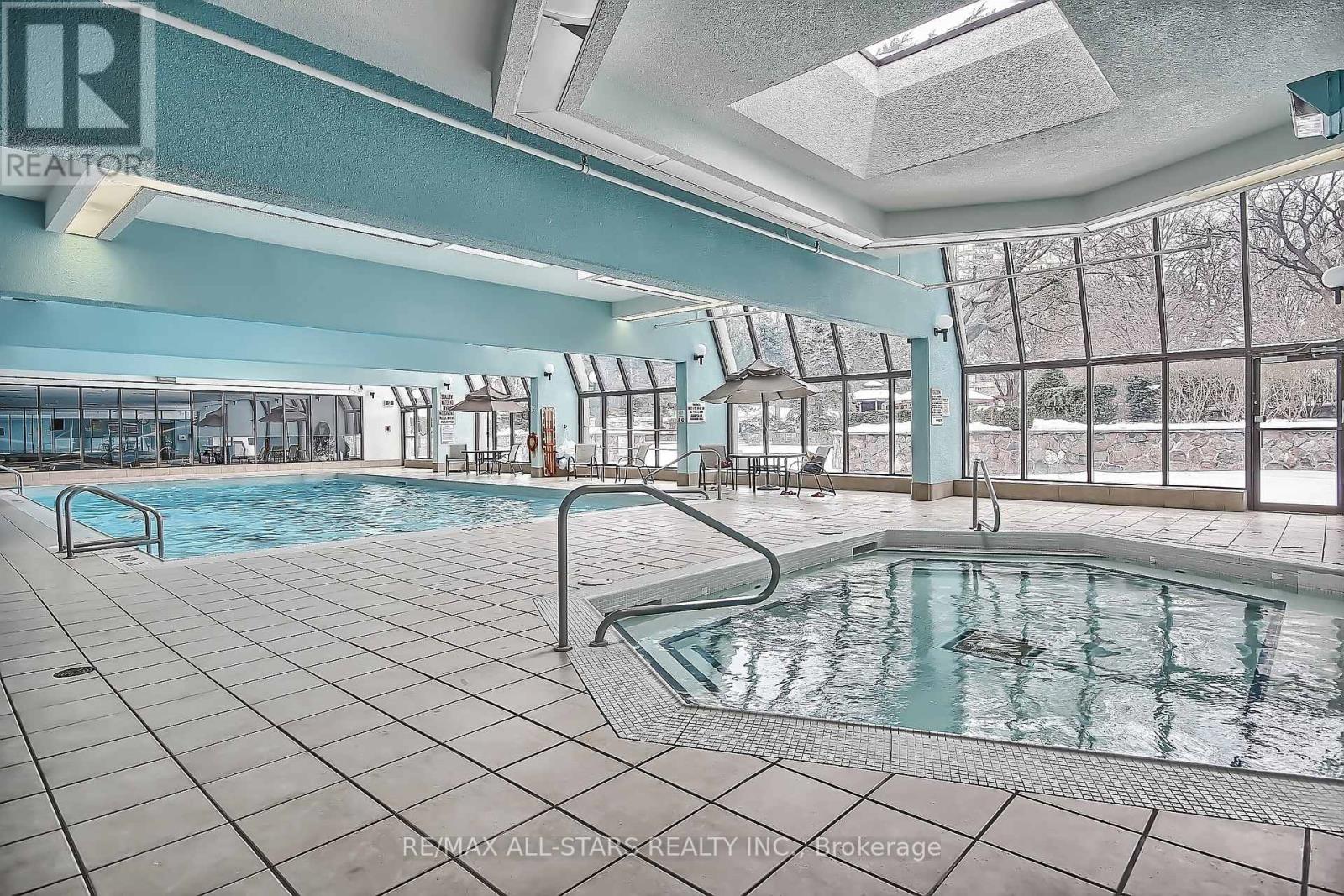 A large indoor pool with a slide and a skylight.