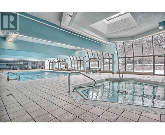 A large indoor pool with a slide and a skylight.