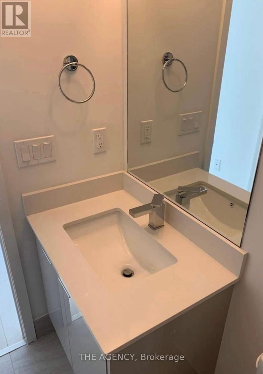 A white bathroom with a sink and mirror.