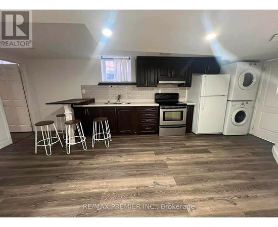 A kitchen with dark wood floors and white appliances.