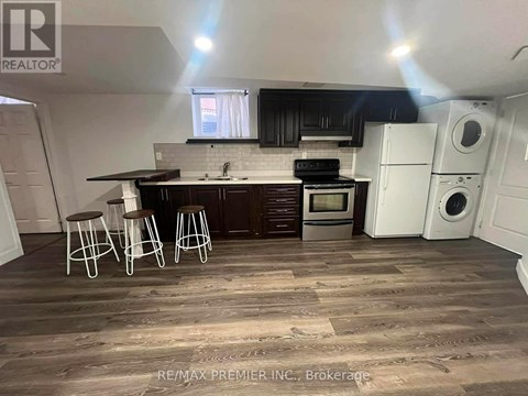 A kitchen with dark wood floors and white appliances.