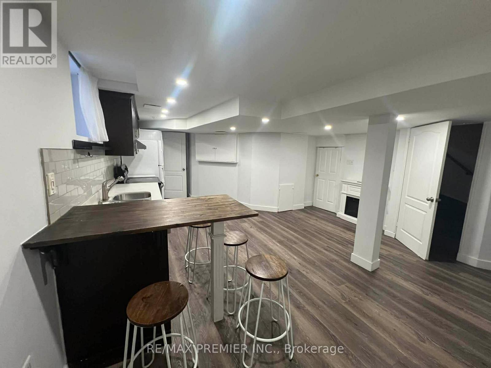 A modern kitchen with a bar area and wooden flooring.