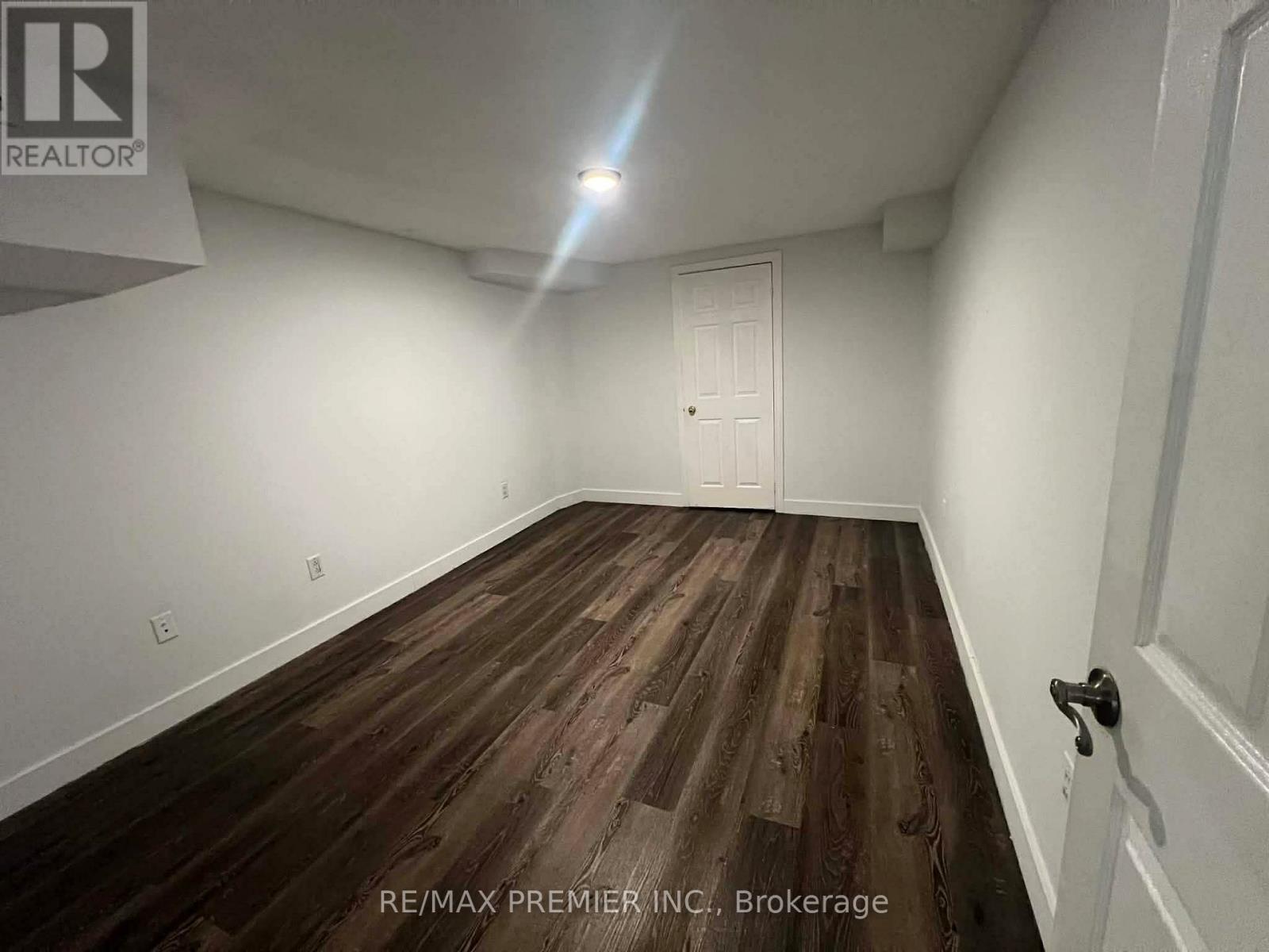 A room with wooden flooring and a white door.