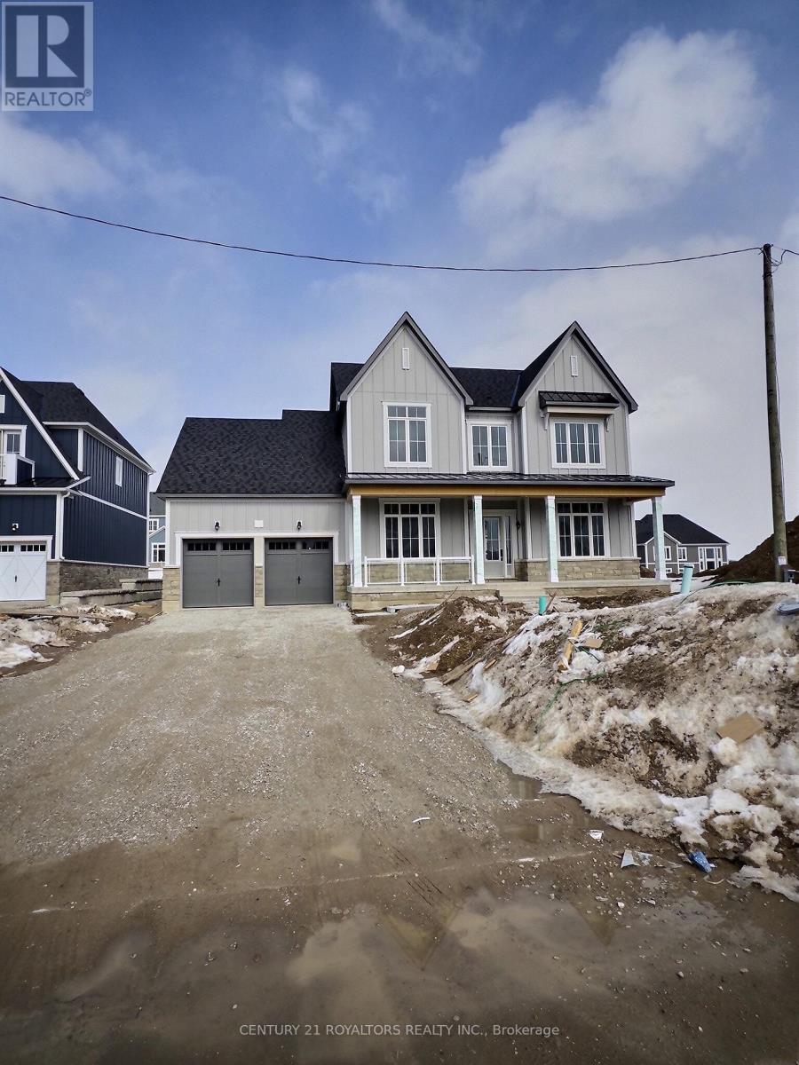 A house under construction with a dirt road leading to the front door.