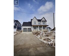 A house under construction with a dirt road leading to the front door.