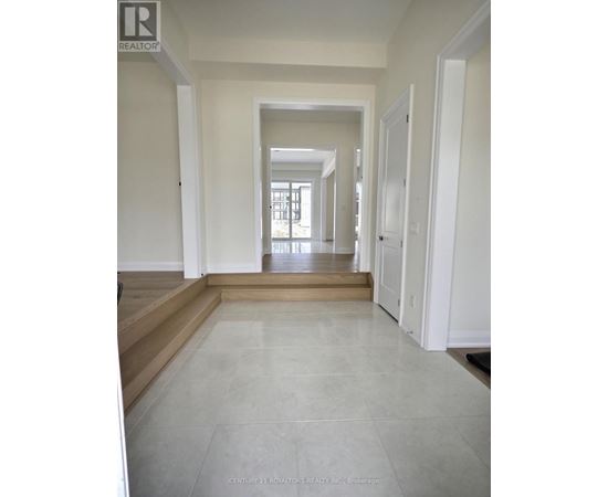 A long hallway with white walls and tile flooring.