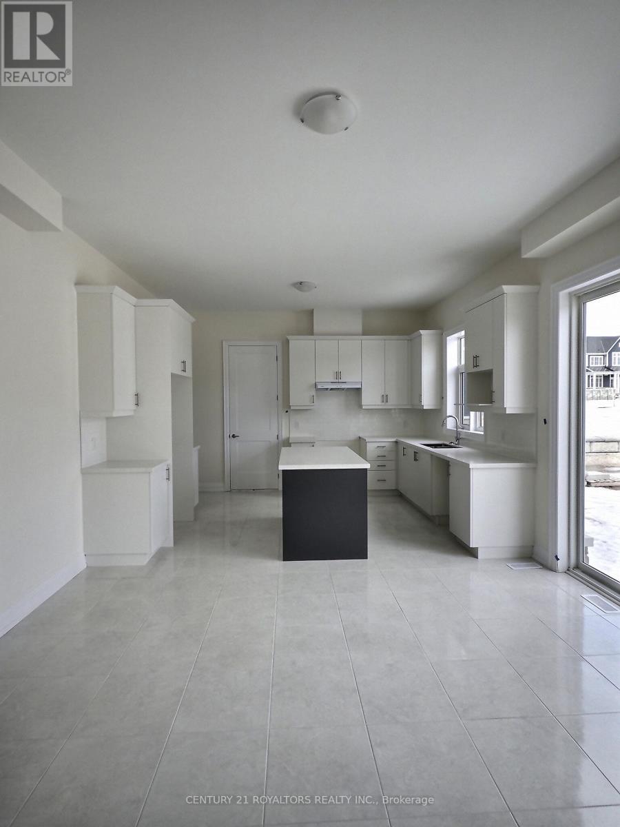 A spacious kitchen with white cabinets and a black island.