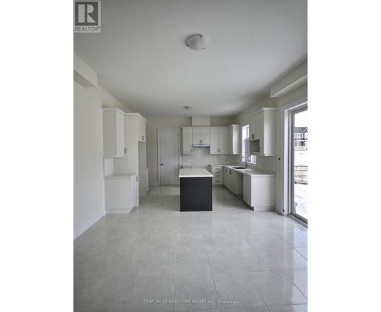 A spacious kitchen with white cabinets and a black island.