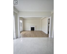 A spacious living room with a fireplace and hardwood floors.