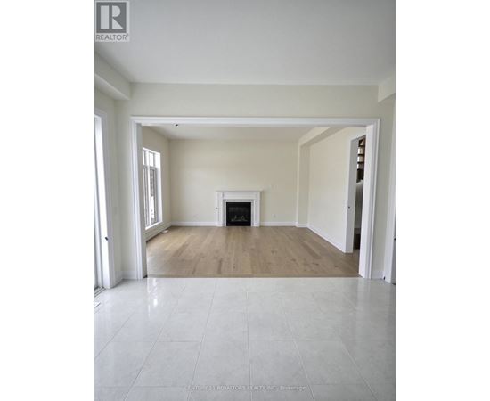 A spacious living room with a fireplace and hardwood floors.