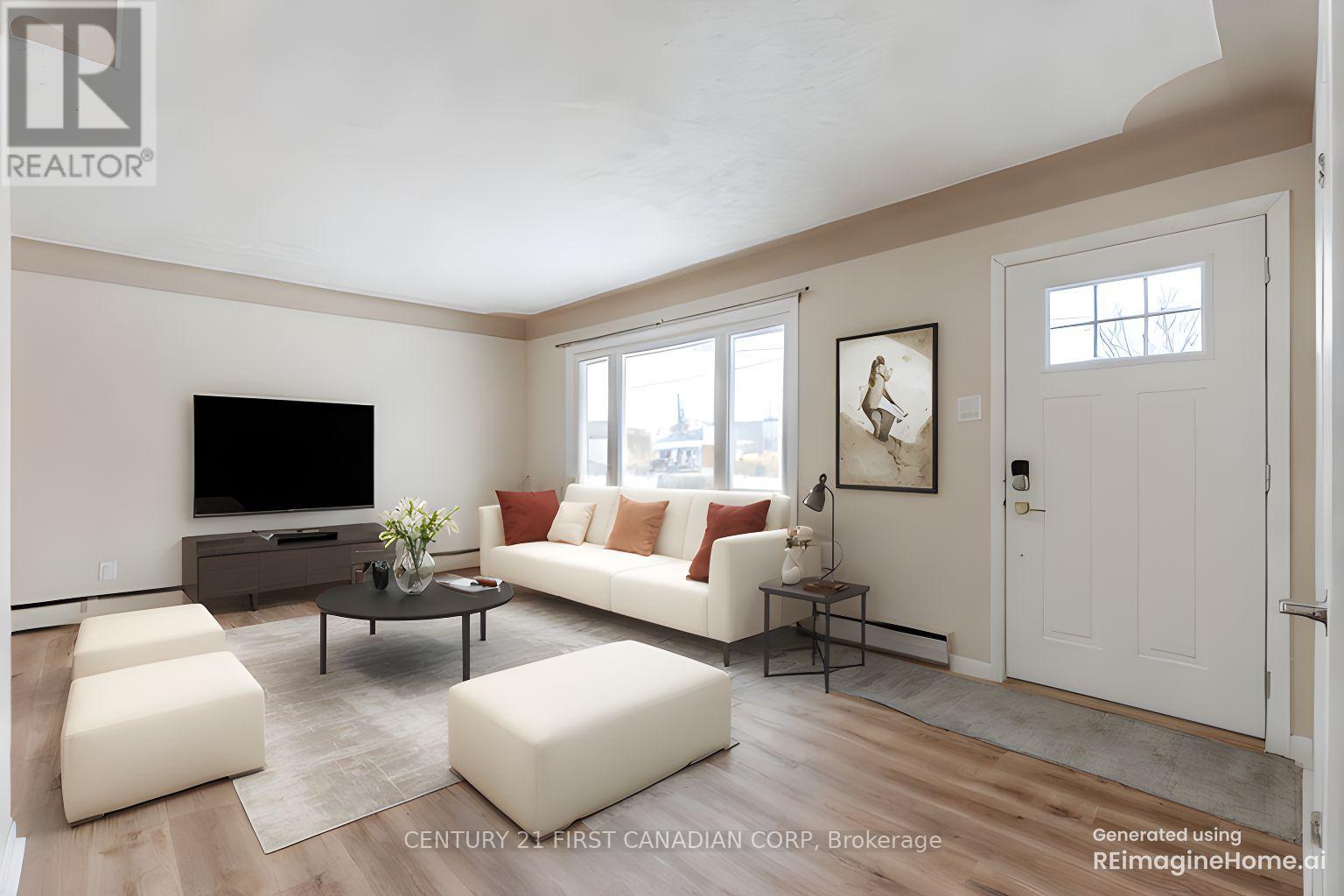 A living room with a white couch, a black coffee table, and a flat screen TV.