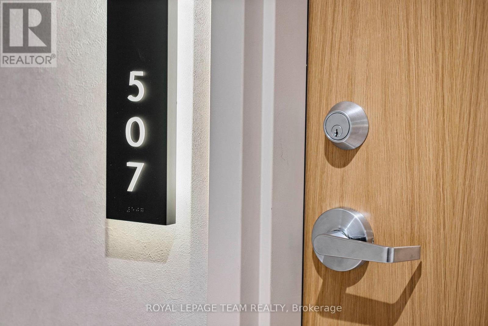 A door with a silver handle and a number 507 on the wall.
