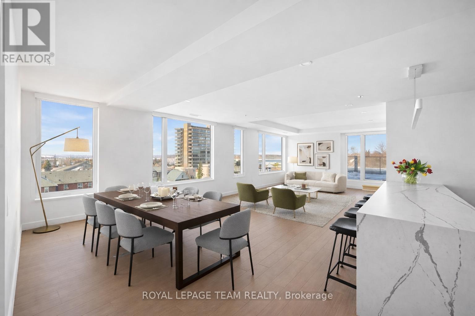 A dining room with a table set for six and a view of the city.
