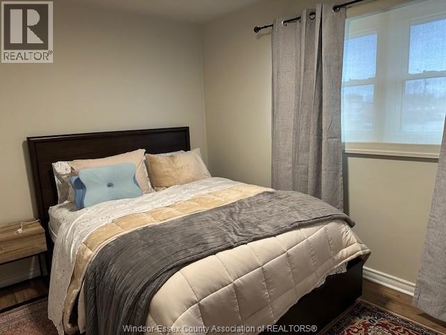 A bedroom with a large bed and a window with curtains.