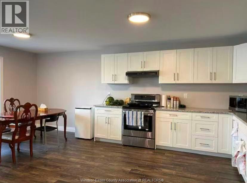 A kitchen with white cabinets and a wooden table.