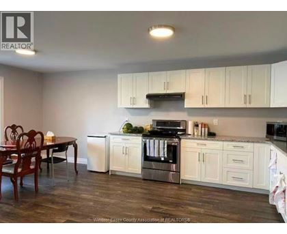 A kitchen with white cabinets and a wooden table.