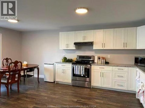 A kitchen with white cabinets and a wooden table.