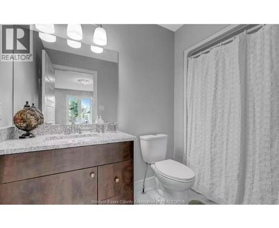 A bathroom with a toilet, sink, and shower curtain.