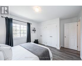 A bedroom with a large bed and a window with curtains.