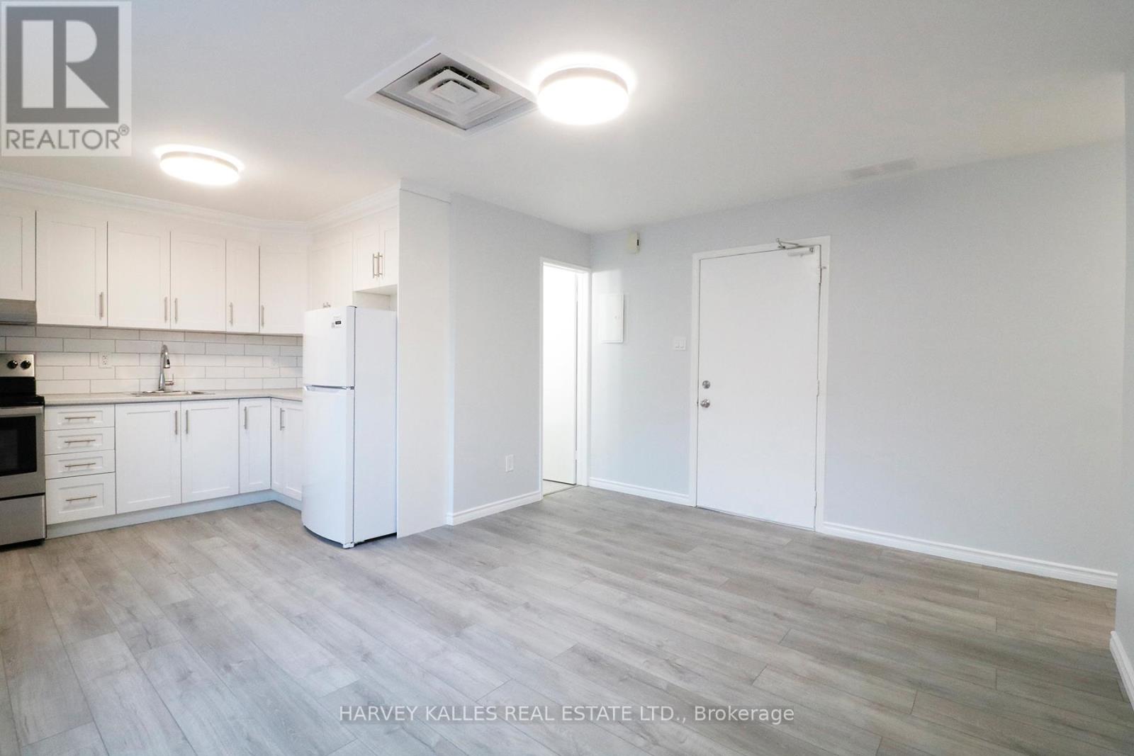 A kitchen with white cabinets and a stainless steel refrigerator.