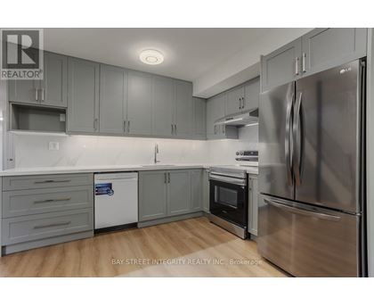 A modern kitchen with stainless steel appliances and grey cabinets.