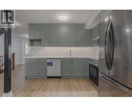 A modern kitchen with stainless steel appliances and grey cabinets.