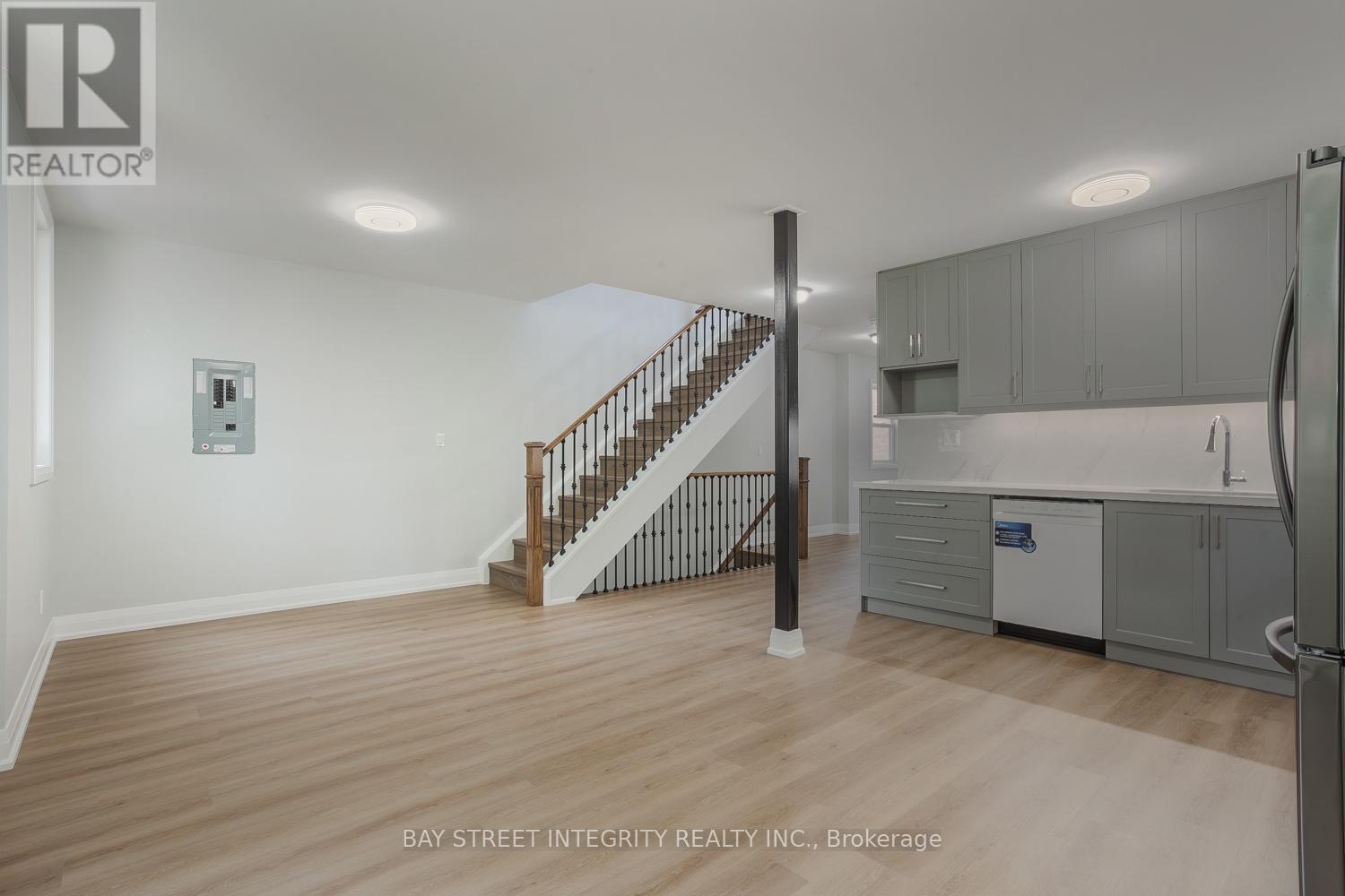 A spacious room with a staircase leading to the upper floor.