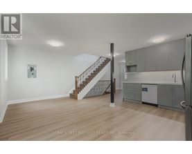 A spacious room with a staircase leading to the upper floor.