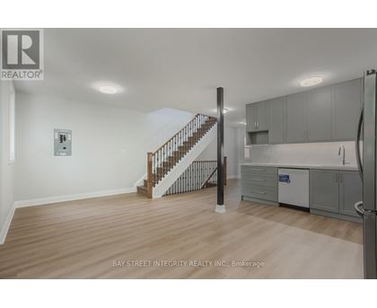 A spacious room with a staircase leading to the upper floor.