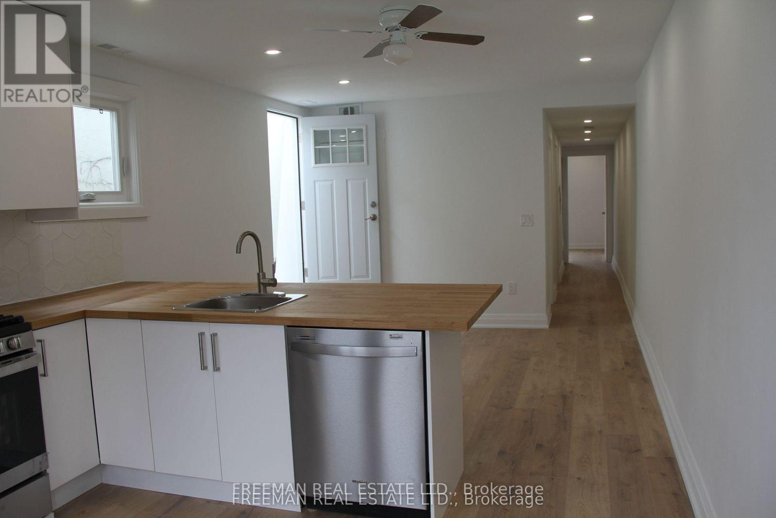 A kitchen with white cabinets and a wooden countertop.