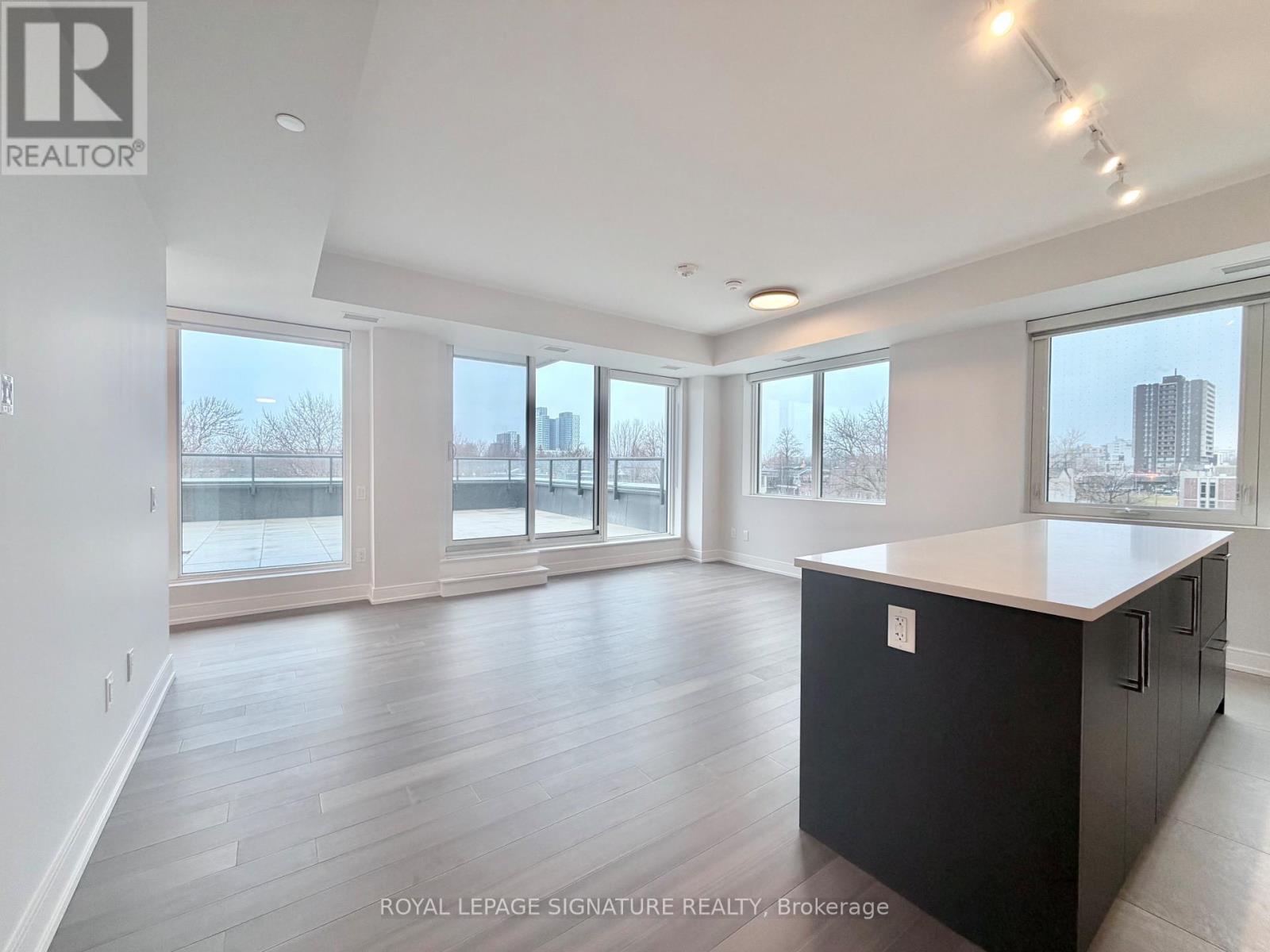 A spacious room with a black cabinet and wooden flooring.
