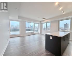 A spacious room with a black cabinet and wooden flooring.