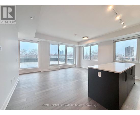 A spacious room with a black cabinet and wooden flooring.