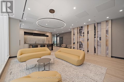 A living room with a yellow sofa and a circular light fixture on the ceiling.