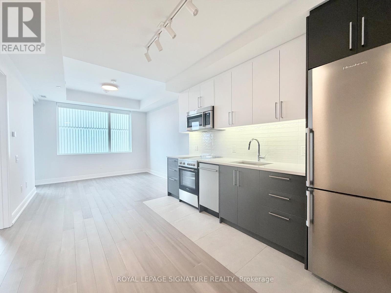 A kitchen with stainless steel appliances and white cabinets.