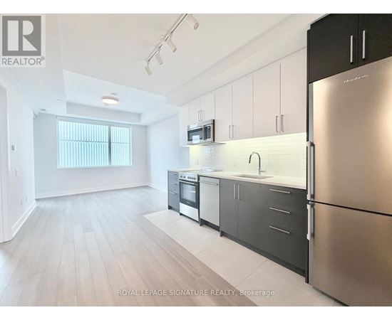 A kitchen with stainless steel appliances and white cabinets.