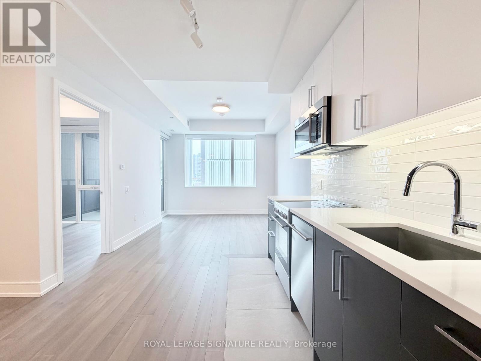 A kitchen with a sink, microwave, and cabinets.