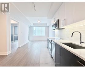 A kitchen with a sink, microwave, and cabinets.