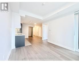 A spacious room with wooden flooring and white walls.
